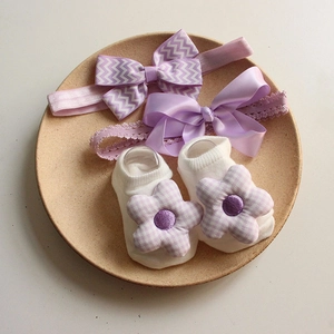 Detailed set of purple bow baby headbands and white knit socks with floral accents