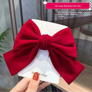 Close-up of a large red velvet bow hair clip with a 5cm metal fastener for girls