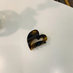 Detail shot of a mini heart-shaped cellulose acetate hair claw with amber tortoise pattern