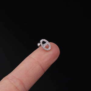 Detail of 20G stainless steel screw ball stud earring with zircon on finger tip
