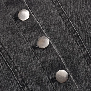 Détail d'une robe en jean gris foncé avec boutons métalliques et texture sergée