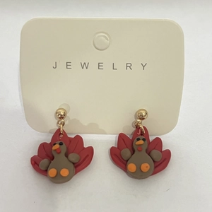 Detail of handmade polymer clay turkey earrings on a jewelry display card for Thanksgiving