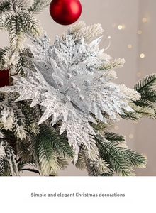 Macro shot of silver sequined Christmas flower with a red ball and snowy pine branch