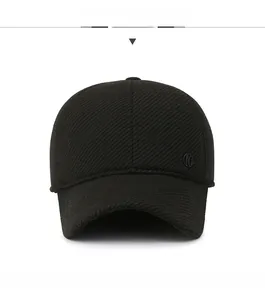 Close-up of black wool blend baseball cap showing twill texture and metal logo detail