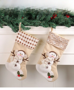 Detail of burlap Christmas stockings with 3D snowman hanging on a white fireplace mantel