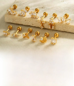Detailed view of gold and silver copper stud earrings with cubic zirconia and steel pins