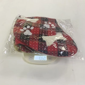 Plaid Christmas stocking with bone and paw prints on a scale weighing 106.0g