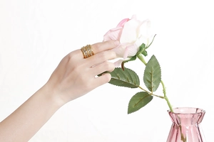 Detail of a stacked wide band ring in gold finish with micro-paved sparkling zircon stones