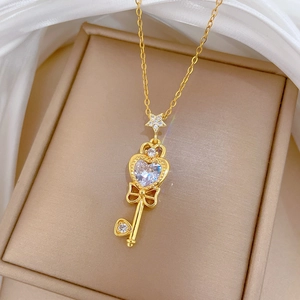Close-up of a gold bow key necklace featuring sparkling cubic zirconia on silk fabric