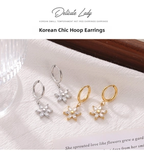 Detailed view of silver and gold sunflower earrings with sparkling cubic zirconia stones
