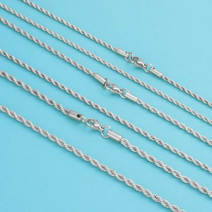 Detalle de cadenas de cuerda trenzada plateadas con cierre de langosta sobre fondo azul