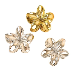 Three minimalist metal flower hair claws in gold, silver, and champagne gold finishes