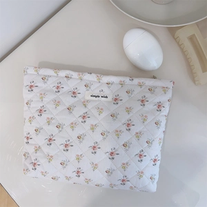 Detail of floral quilted cosmetic bag with simple wish label and soft diamond texture