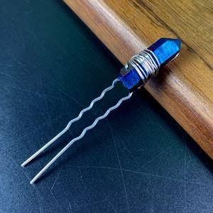 Macro shot of iridescent crystal U-shaped hairpin with silver wire wrapping detail