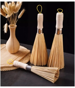 Detail of three durable bamboo kitchen brushes with wooden handles and hanging loops