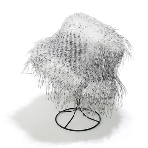 Winter faux turkey fur bucket hat in white with black spotted pattern on metal stand