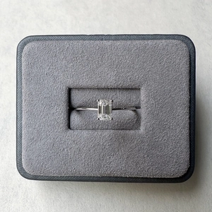 Macro shot of 0.8ct emerald cut moissanite ring in S925 silver on grey velvet display box