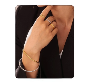 Model wearing bow-shaped rings and minimalist bangle set in gold and silver finish