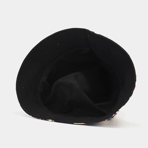Detail view of a dual-sided bucket hat featuring black lining and colorful floral print edge