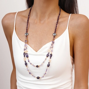 Close-up of multi-layer long necklace with purple crystal beads on a female model