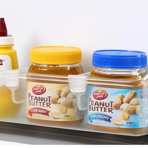 Detailed view of adjustable transparent storage box hanging on a refrigerator side door shelf