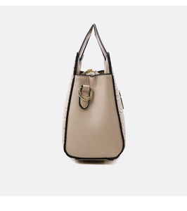 Detail of beige crocodile embossed handbag showing side D-ring and black edge oil finish