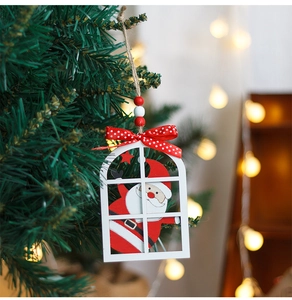 Detail of wooden Santa ornament with polka dot bow hanging on a festive Christmas tree