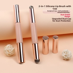 Close-up of dual-ended silicone lip brush with rose gold caps and pink handles