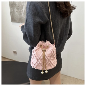 Detailed back view of pink denim bucket bag with gold chain and pearl drawstring charms