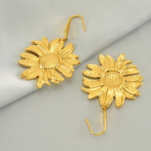 Elegant gold sunflower drop earrings with hammered petals on grey silk background