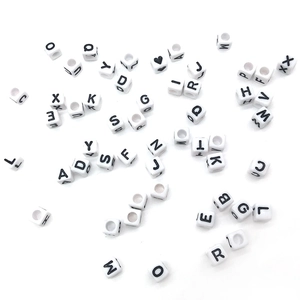 Macro shot of white alphabet beads with black letters for DIY jewelry making