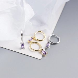 Detail of 925 sterling silver hoop earrings with rectangular purple zircon pendants