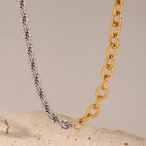 Macro shot of two-tone stainless steel necklace with silver rope and gold oval chain links