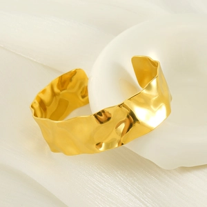 Polished 18K gold wide hammered cuff bangle in minimalist stainless steel jewelry design