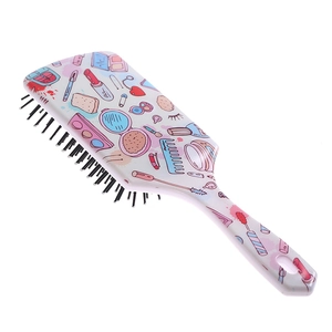 Detail of large air cushion hairbrush featuring colorful cartoon makeup patterns on handle