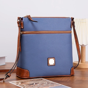 Macro detail of blue lychee texture leather crossbody bag with brown trim and gold hardware