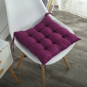 Detail of purple thick chair cushion with secure ties on a white chair in a home setting