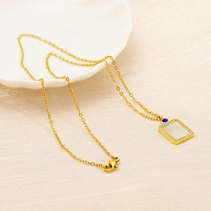 Gold necklace with rectangular shell pendant featuring colored zircon and a blue gemstone