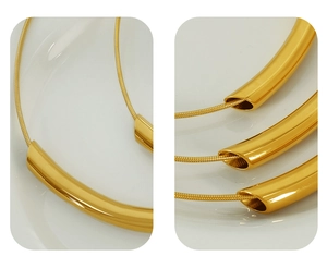 Detail of 18k gold plated curved tube pendant on sleek snake chain necklace