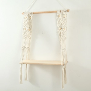 Close-up of hand-woven cotton macrame shelf with wooden beads and elegant tassel details