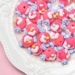 Vue macro de perles en forme de bonbon rose et blanc pour la création de bijoux DIY