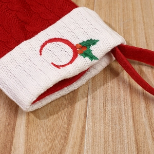 Red knit Christmas stocking with white cuff featuring embroidered letter C and holly berry leaf
