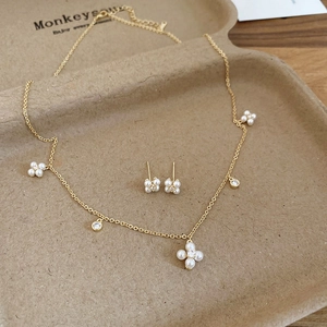 Detailed macro view of gold-plated flower jewelry set with pearls and zircons
