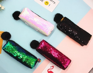 Detailed view of sequin stationery bags in four colors with decorative fur pompom charms