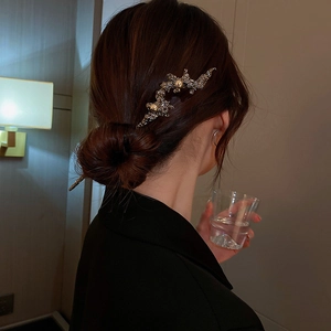Detail of silver lava textured hair pin worn in a bun with elegant rhinestone accents