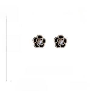 Detail of camellia flower earrings with black and white enamel and 925 silver needles