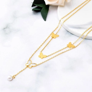 Double-layered gold necklace with butterfly pendants, white shell inlay and a single pearl