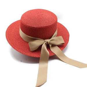 Elegante cappello di paglia rosso con un lungo fiocco di raso champagne da donna