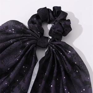 Détail d'un chouchou d'Halloween violet avec motifs chauve-souris noire et toile d'araignée