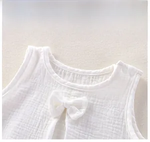 Gros plan d'un body bébé en gaze de coton blanc avec nœud et boutons-pression épaule